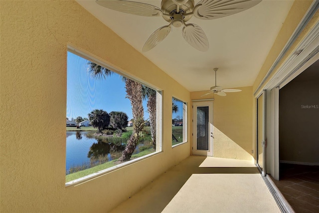 exterior space with ceiling fan and a water view