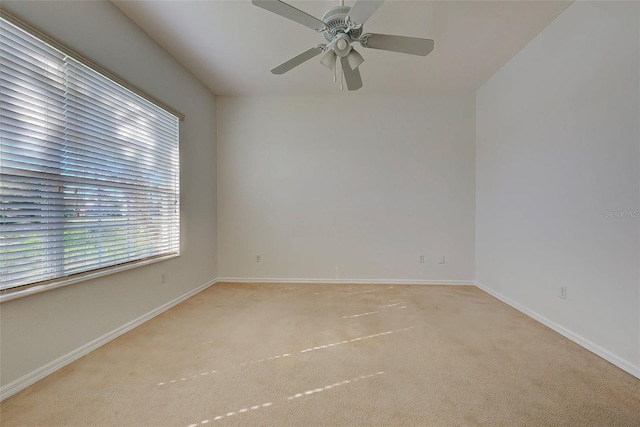 unfurnished room with light colored carpet and ceiling fan