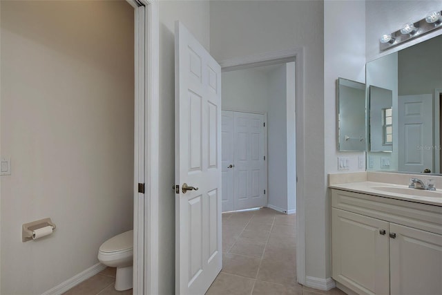 bathroom with toilet, tile patterned flooring, and vanity