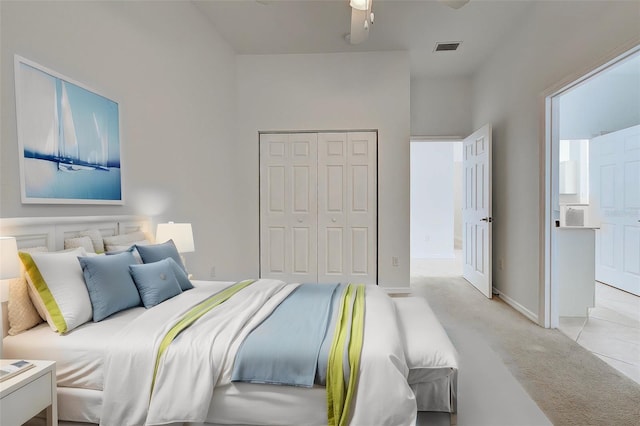 carpeted bedroom with ceiling fan and a closet