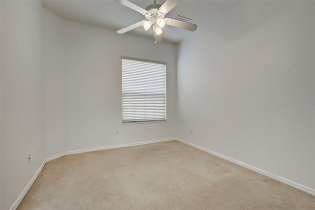 spare room with ceiling fan and light colored carpet