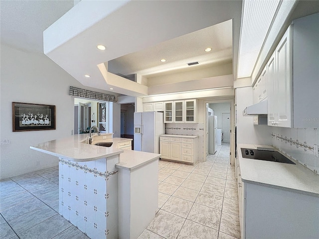 kitchen featuring white cabinetry, sink, white refrigerator with ice dispenser, white fridge, and black electric cooktop