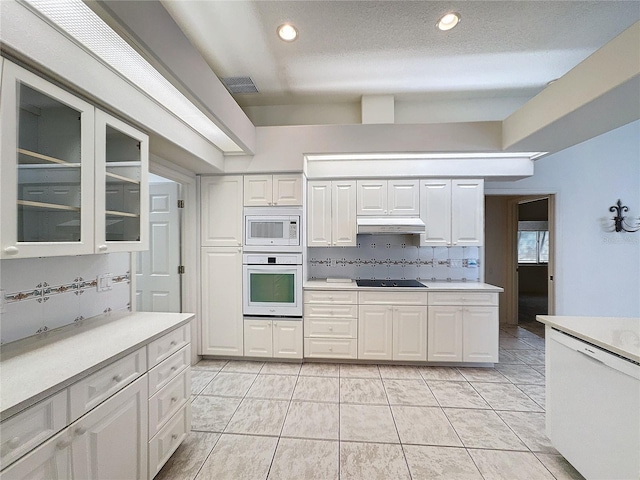 kitchen with backsplash, white cabinets, and white appliances