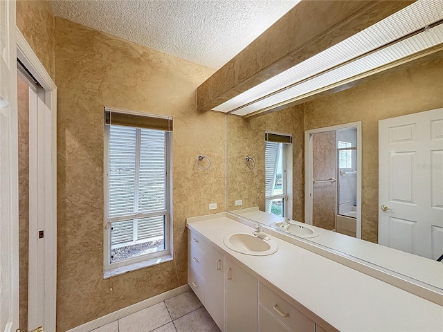 bathroom with tile patterned flooring, vanity, and a textured ceiling