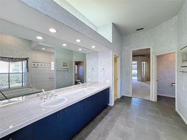 bathroom featuring vanity, toilet, a bathtub, and a textured ceiling