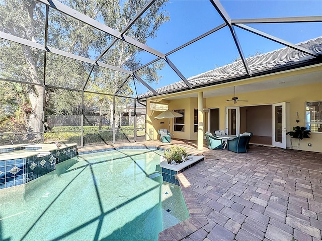 view of pool with an in ground hot tub, ceiling fan, a patio area, and glass enclosure