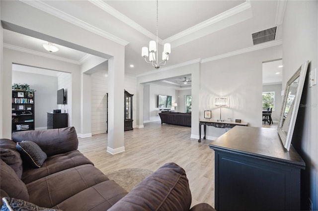 living room with ceiling fan, ornamental molding, a tray ceiling, and light hardwood / wood-style flooring