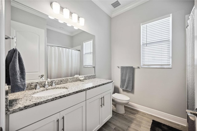 bathroom featuring ornamental molding, vanity, and toilet