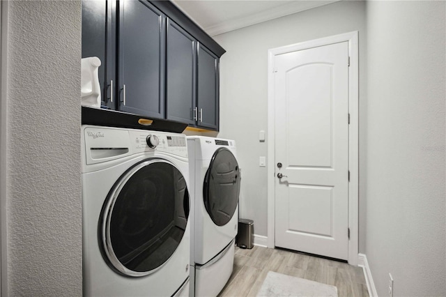 clothes washing area with cabinets, ornamental molding, washer and dryer, and light wood-type flooring