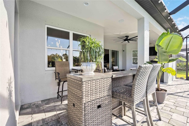 view of patio / terrace featuring ceiling fan and a bar