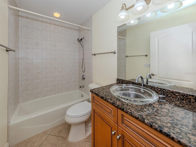 full bathroom with tiled shower / bath, vanity, tile patterned floors, and toilet