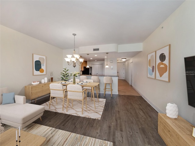 dining space featuring hardwood / wood-style flooring and a chandelier