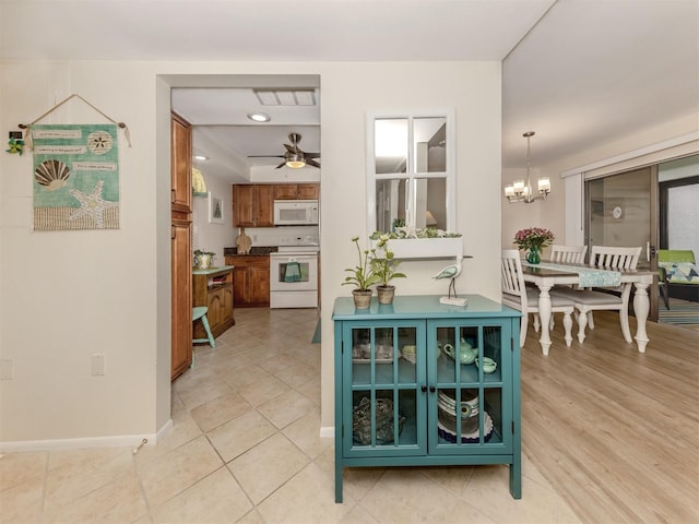 dining space featuring ceiling fan with notable chandelier and light tile patterned floors