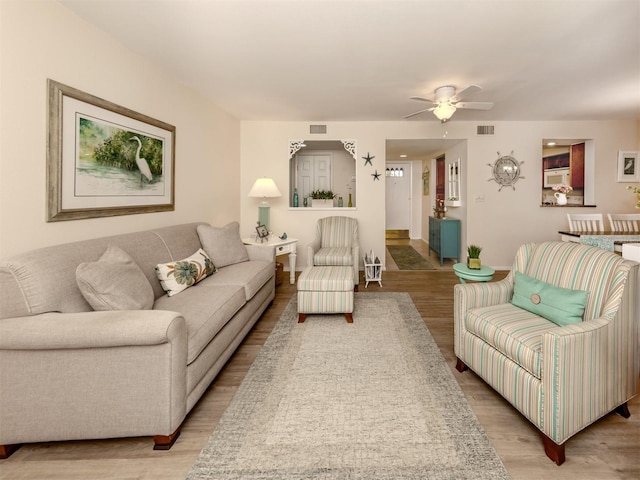 living room featuring ceiling fan and light wood-type flooring