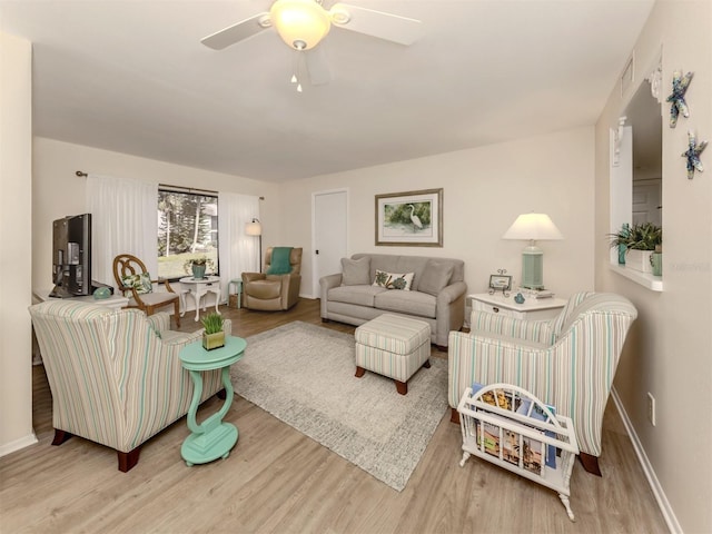 living room with wood-type flooring and ceiling fan