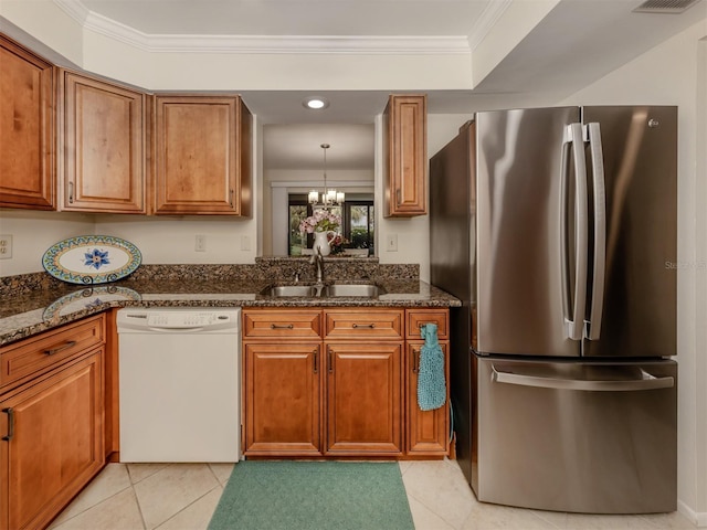 kitchen featuring sink, crown molding, stainless steel refrigerator, dishwasher, and dark stone countertops