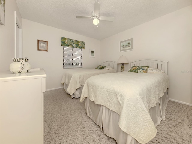 carpeted bedroom featuring ceiling fan and a textured ceiling