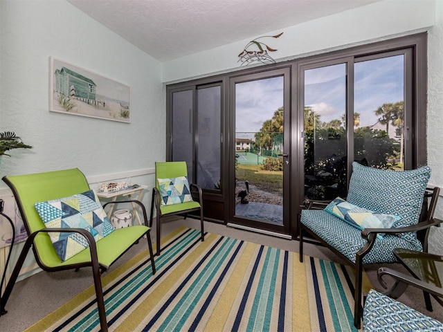 living area with carpet floors, plenty of natural light, and a textured ceiling