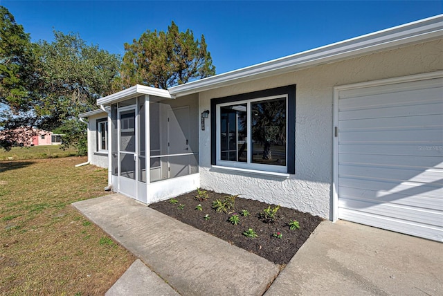 property entrance featuring a garage and a yard