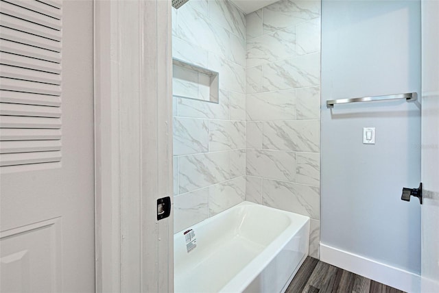 bathroom with hardwood / wood-style flooring and tiled shower / bath