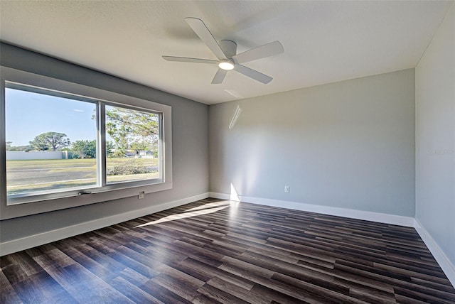 empty room with ceiling fan and dark hardwood / wood-style floors