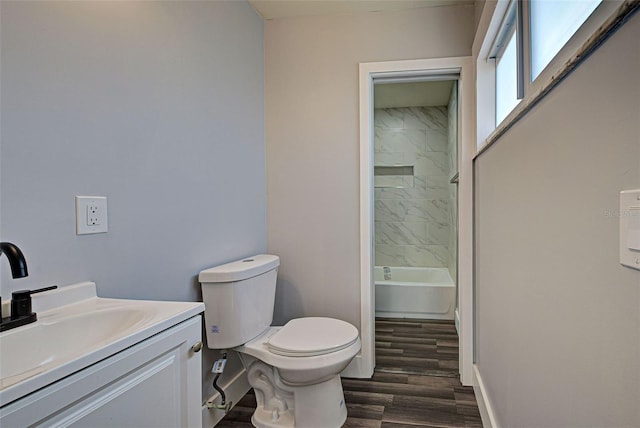 full bathroom with vanity, toilet, tiled shower / bath combo, and wood-type flooring