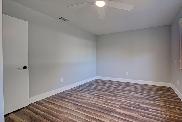 unfurnished room with dark wood-style floors, ceiling fan, visible vents, and baseboards