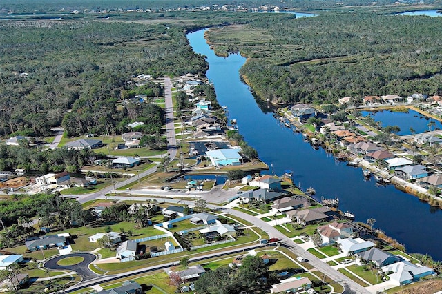 drone / aerial view featuring a water view, a wooded view, and a residential view