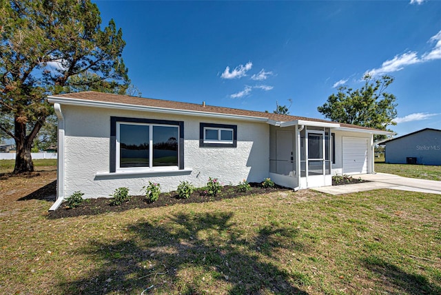 ranch-style house featuring an attached garage, driveway, a front yard, and stucco siding