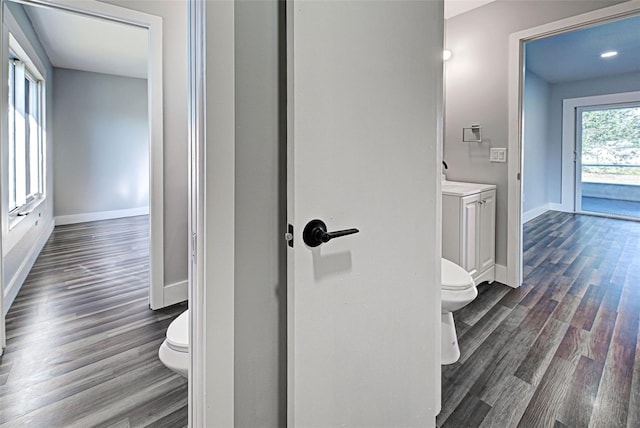 bathroom featuring baseboards, vanity, toilet, and wood finished floors