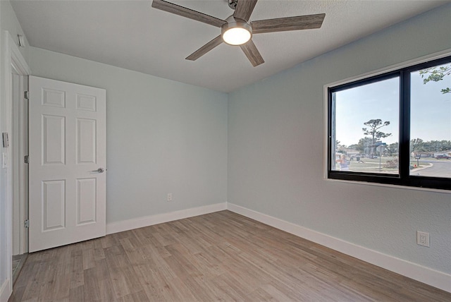 empty room with ceiling fan and light wood-type flooring