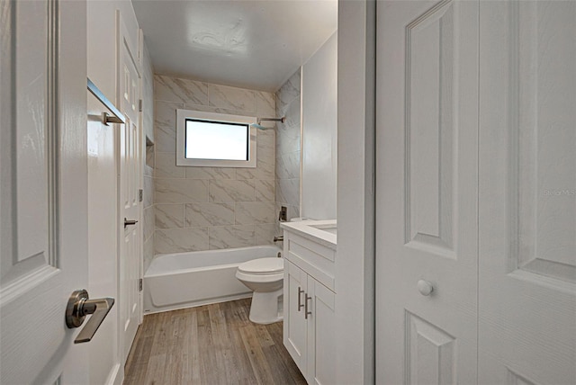 full bath with shower / bathtub combination, vanity, wood finished floors, and toilet