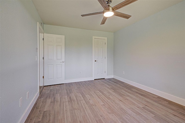 unfurnished bedroom with a ceiling fan, light wood-style flooring, and baseboards