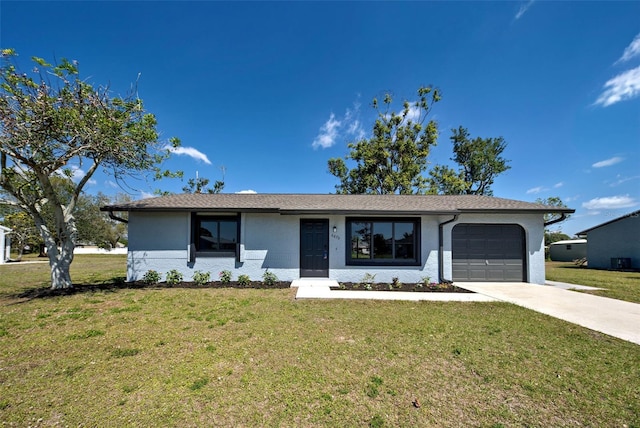 single story home featuring a front yard, driveway, and an attached garage