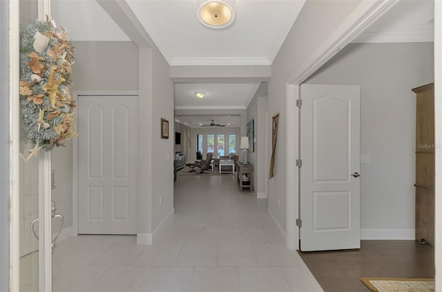 tiled foyer entrance featuring crown molding and ceiling fan