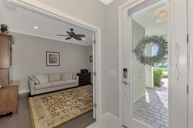 foyer entrance with crown molding, light hardwood / wood-style flooring, and ceiling fan