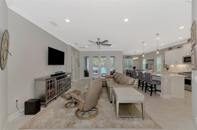 living room featuring french doors, light tile patterned flooring, sink, ornamental molding, and ceiling fan