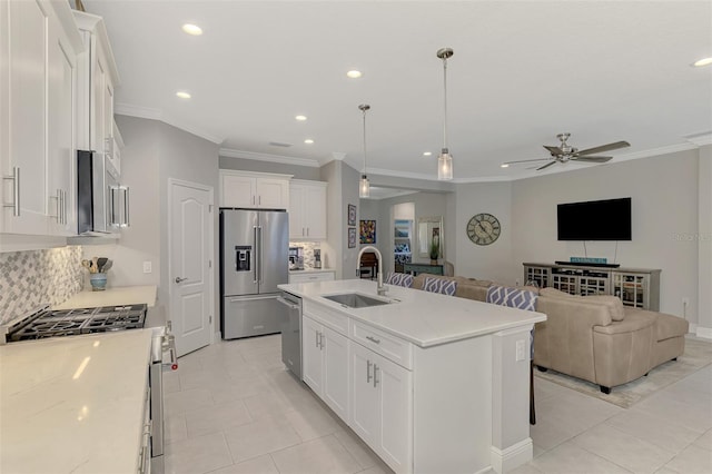 kitchen featuring stainless steel appliances, sink, a kitchen island with sink, and white cabinets