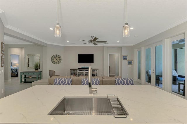 kitchen featuring crown molding, ceiling fan, light stone counters, and decorative light fixtures