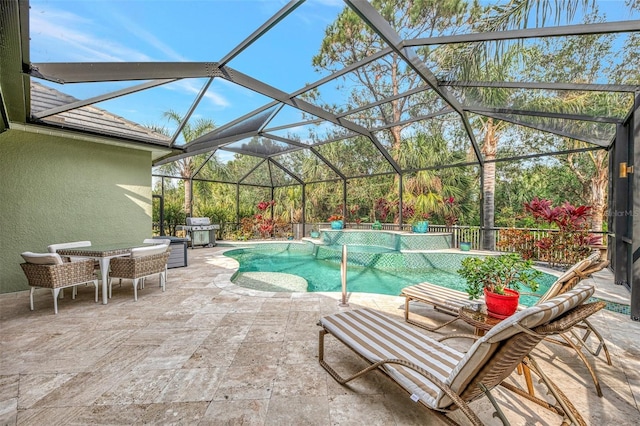 view of pool featuring grilling area, a patio, and glass enclosure