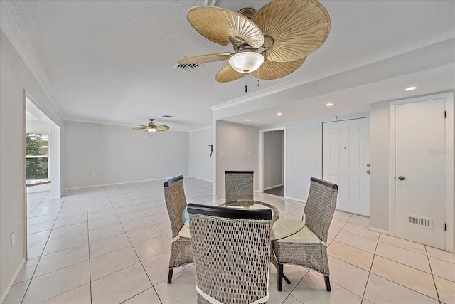 dining area with light tile patterned floors, a textured ceiling, ornamental molding, and ceiling fan