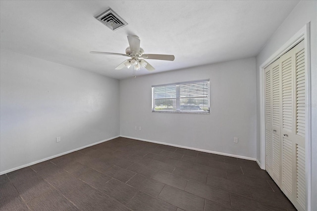 unfurnished bedroom featuring ceiling fan and a closet