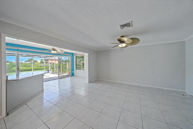 empty room featuring light tile patterned flooring, ornamental molding, a textured ceiling, and ceiling fan