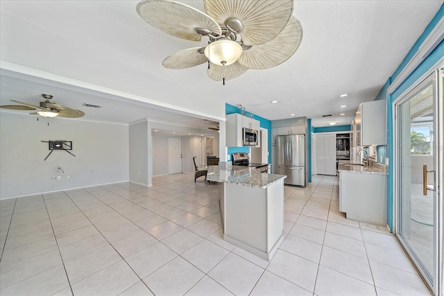 kitchen with ceiling fan, appliances with stainless steel finishes, white cabinetry, light stone counters, and kitchen peninsula