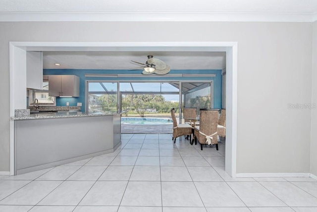 living room with light tile patterned flooring, ceiling fan, crown molding, and sink