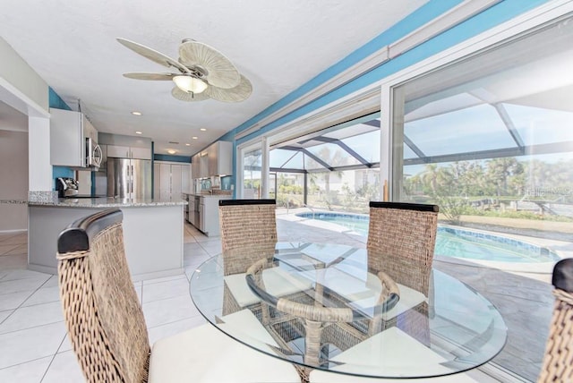 dining space with ceiling fan, sink, and light tile patterned floors