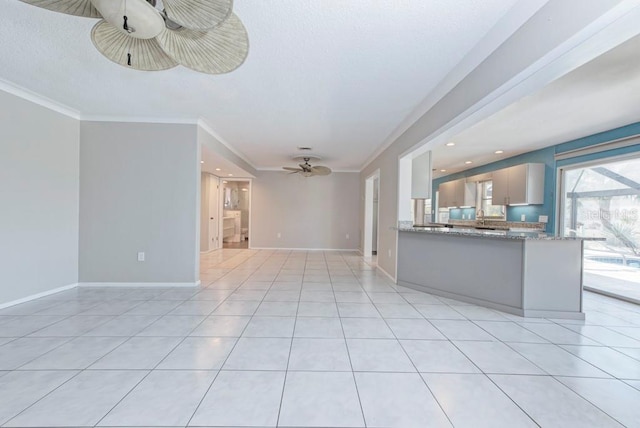 unfurnished living room with ornamental molding, light tile patterned floors, and ceiling fan