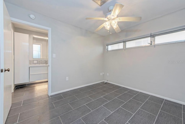 unfurnished room featuring ceiling fan and a wealth of natural light