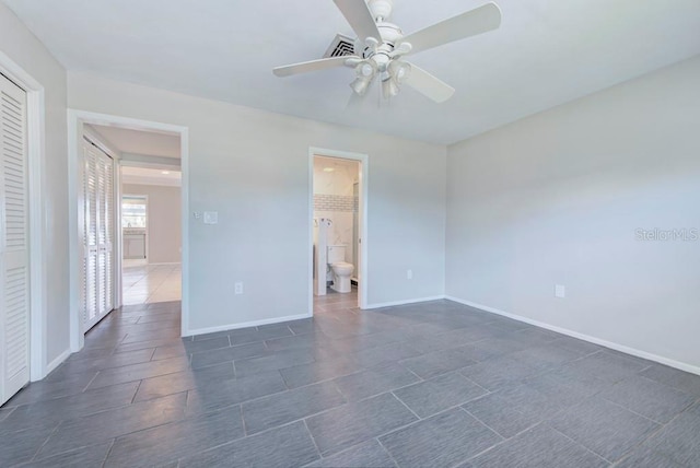 unfurnished room with dark tile patterned flooring and ceiling fan