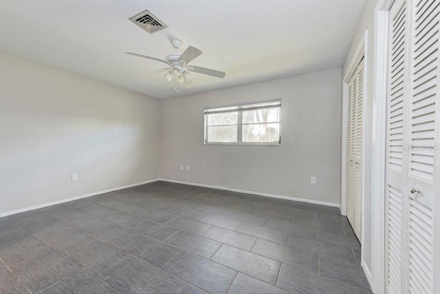 unfurnished bedroom with ceiling fan and a closet